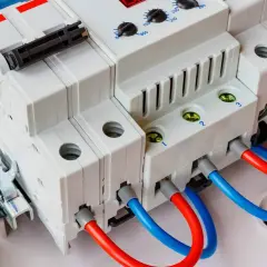 Nowoczesna przepięciówka z czerwonymi i niebieskimi przewodami, gotowa chronić instalację elektryczną.
