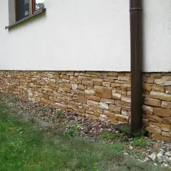 Kamienny cokół domu, ozdobiony naturalnym kamieniem, chroni ściany i dodaje uroku.
