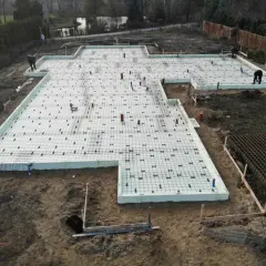 Budowa domu w toku. Widać zbrojenie i styropian na płycie fundamentowej, przygotowywanej pod fundament punktowy.