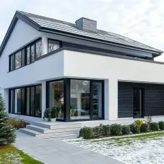 Nowoczesny dom z białymi ścianami i czarnymi oknami. Świetny pomysł na elewację domu, który wygląda elegancko i minimalistycznie.