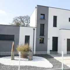 Nowoczesny dom kostka z dwukolorową elewacją, szaro-białą, z dużymi oknami i garażem.