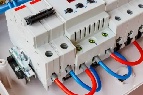Nowoczesna przepięciówka z czerwonymi i niebieskimi przewodami, gotowa chronić instalację elektryczną.