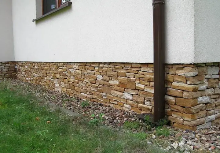 Kamienny cokół domu, ozdobiony naturalnym kamieniem, chroni ściany i dodaje uroku.