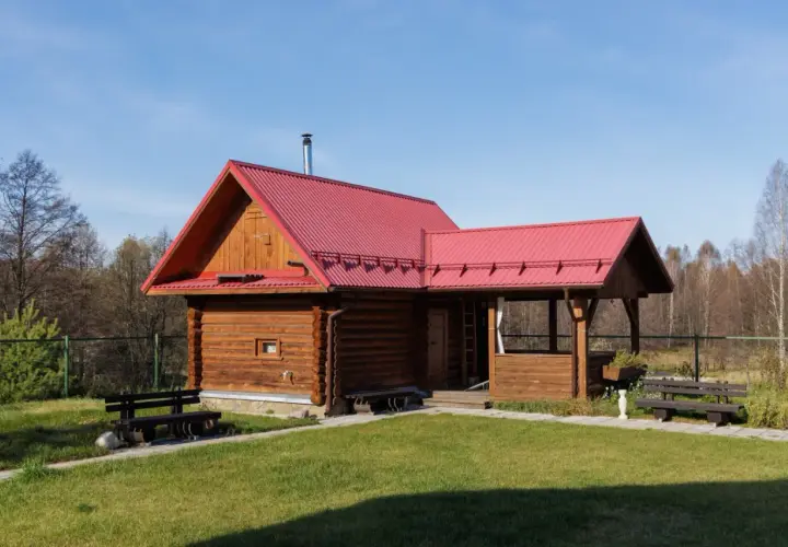 Drewniany domek z czerwoną dachem, idealny na wynajem. Możliwa dotacja na taki domek.