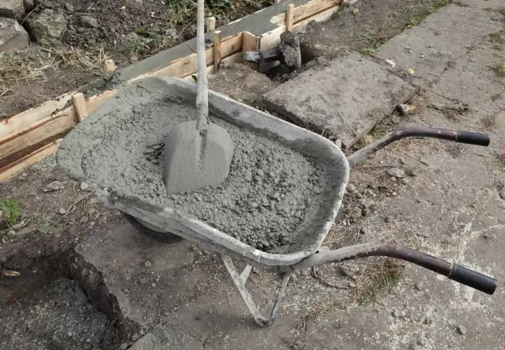 Taczka z betonem i łopatą, gotowa do wylania zbrojenia ławy fundamentowej 40x60.