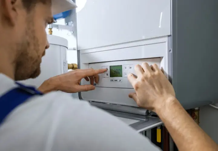 Technik reguluje piec gazowy, sprawdzając koszt instalacji gazowej.
