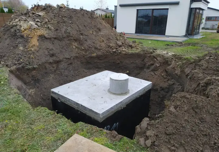 Rozpoczęty montaż zbiornika na deszczówkę w wykopie obok domu.