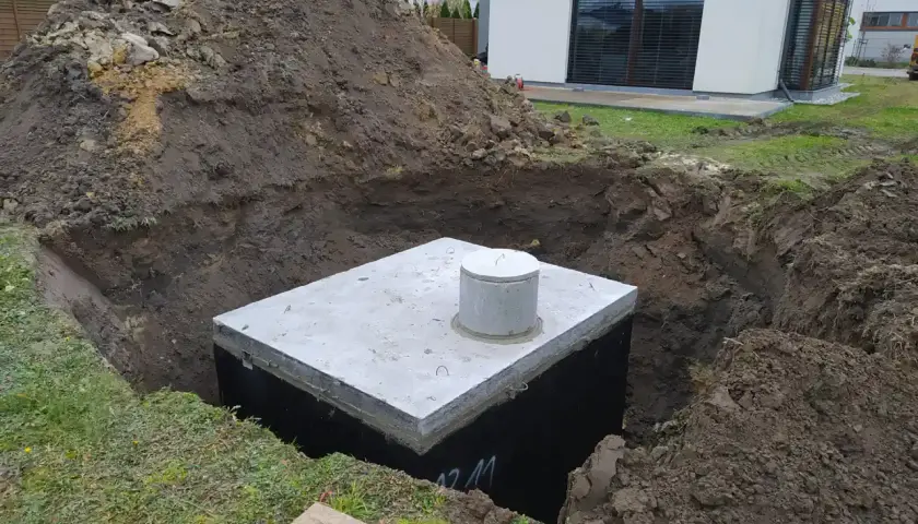 Rozpoczęty montaż zbiornika na deszczówkę w wykopie obok domu.