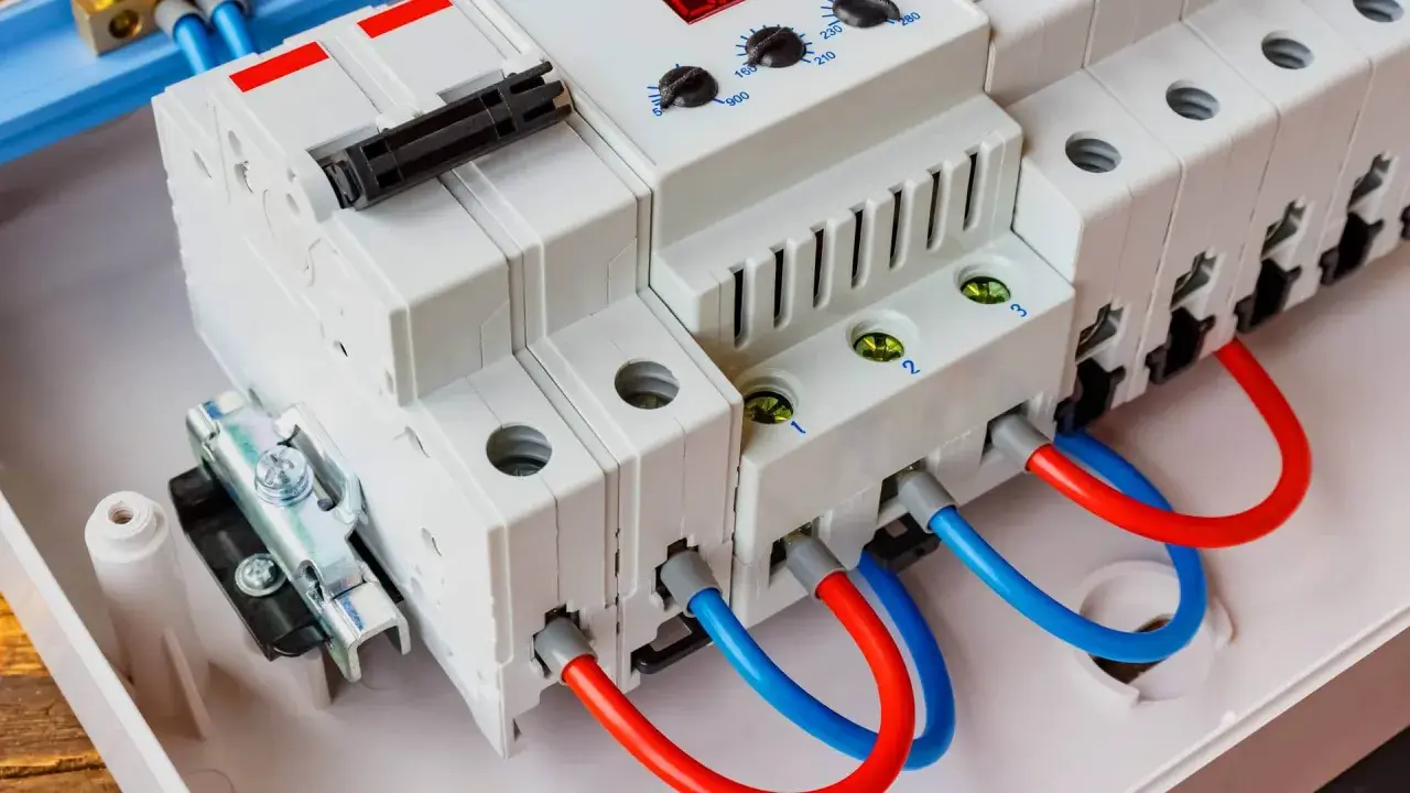 Nowoczesna przepięciówka z czerwonymi i niebieskimi przewodami, gotowa chronić instalację elektryczną.
