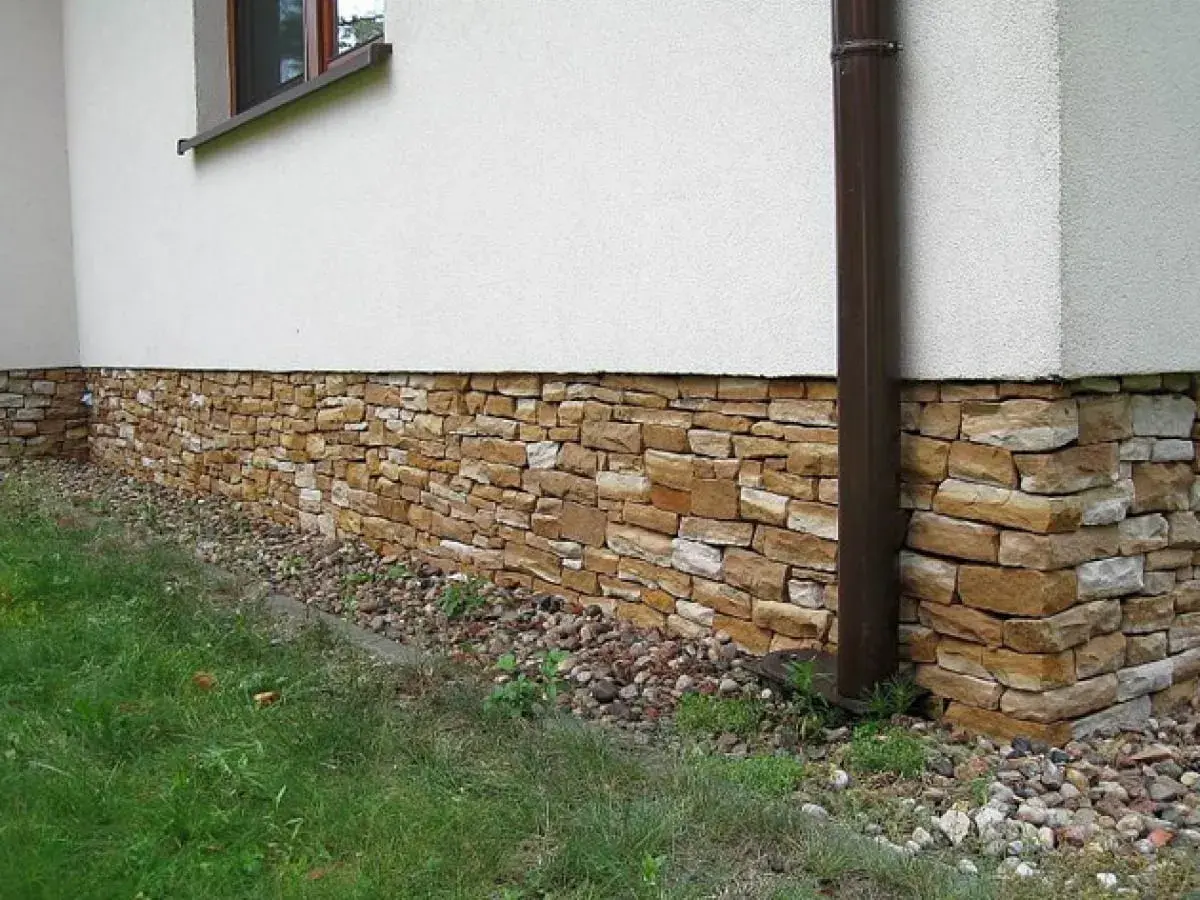 Kamienny cokół domu, ozdobiony naturalnym kamieniem, chroni ściany i dodaje uroku.
