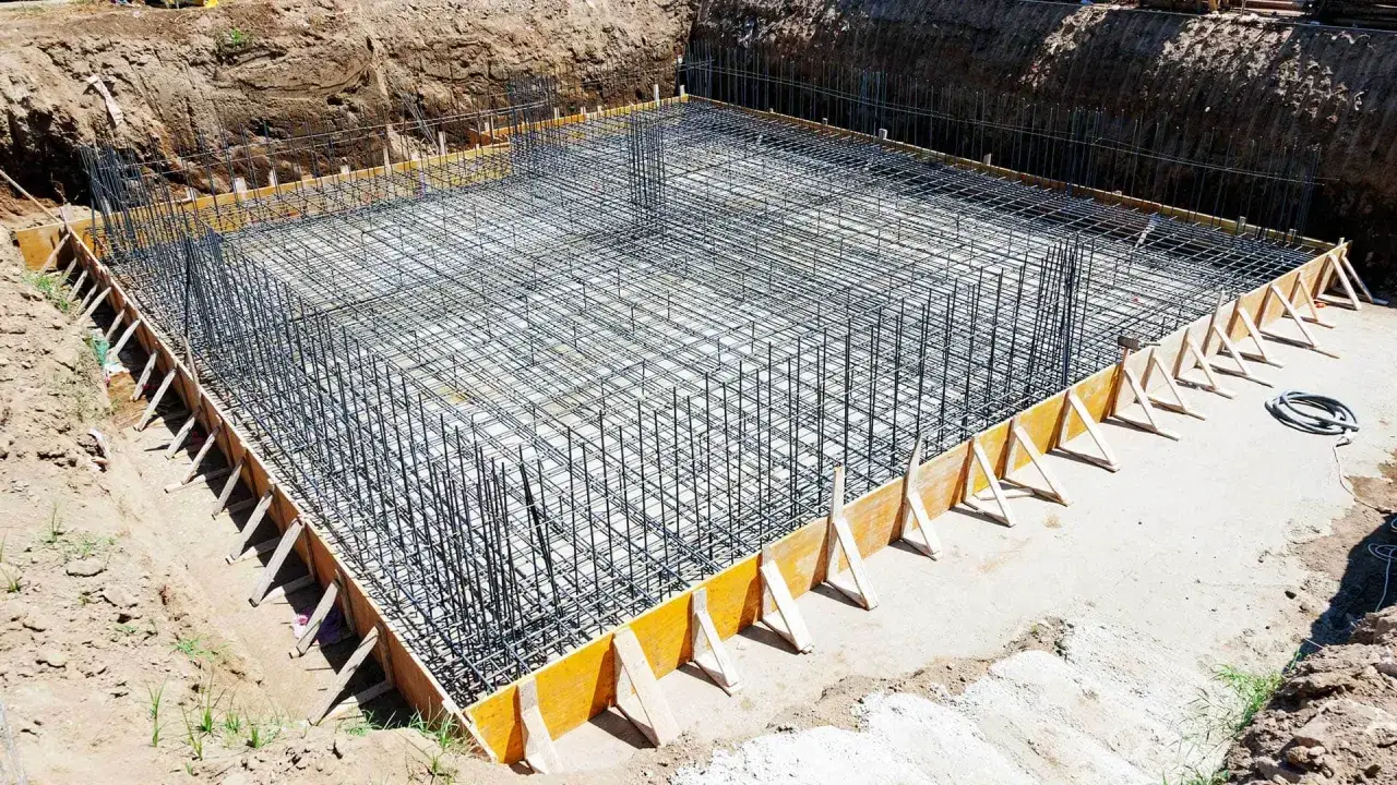 Szkielet zbrojeniowy dla ław fundamentowych w wykopie budowlanym.